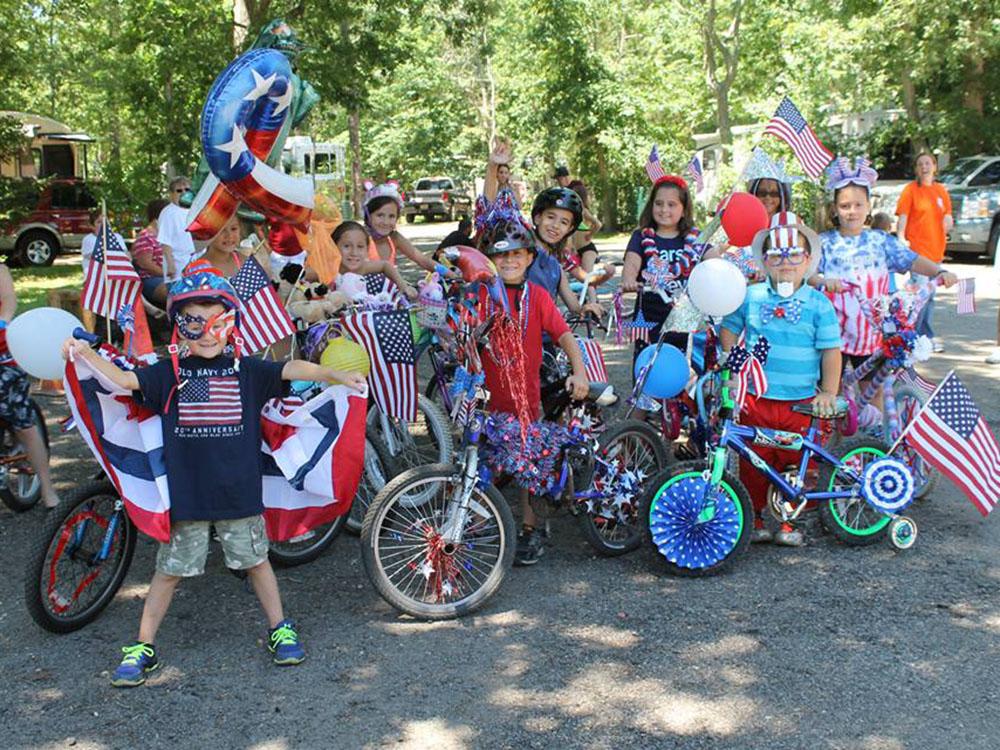 Group of children displaying decorated bikes in red, white and blue at BUTTERFLY CAMPING RESORT