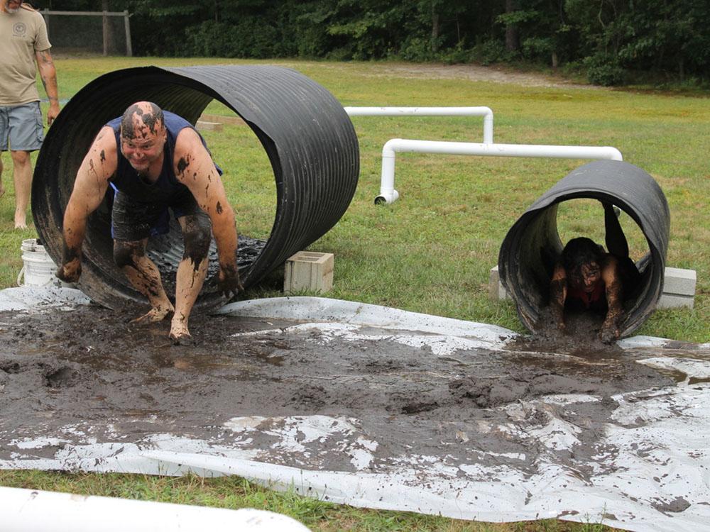 Man full of mud racing through a tunnel at BUTTERFLY CAMPING RESORT