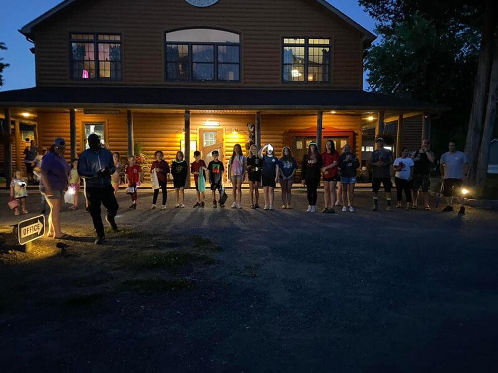 Night photo with children standing in front of lit campground office at BUTTERFLY CAMPING RESORT