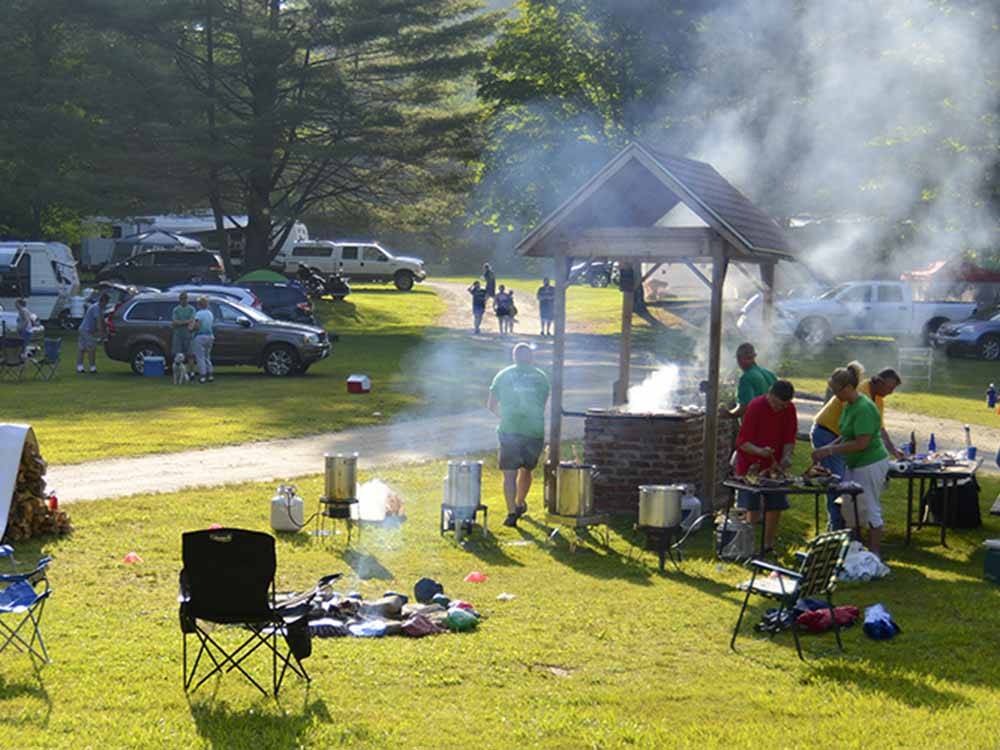 People barbecuing around the fire pit at HORSESHOE ACRES