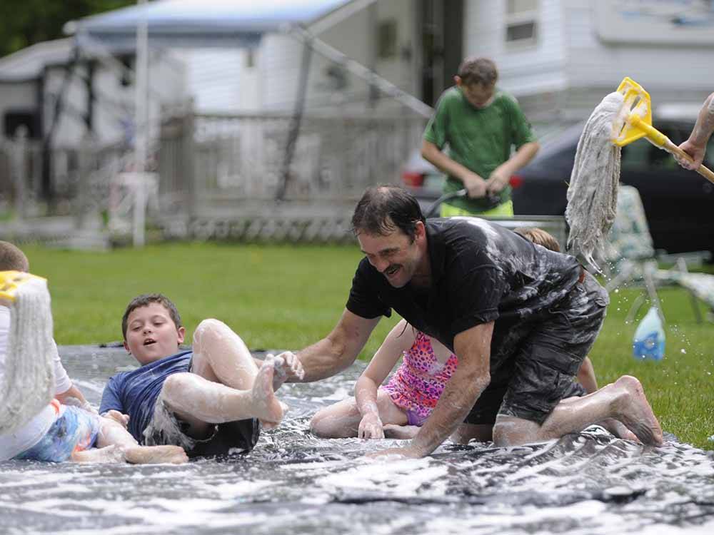 People playing on a slip and slide at HORSESHOE ACRES