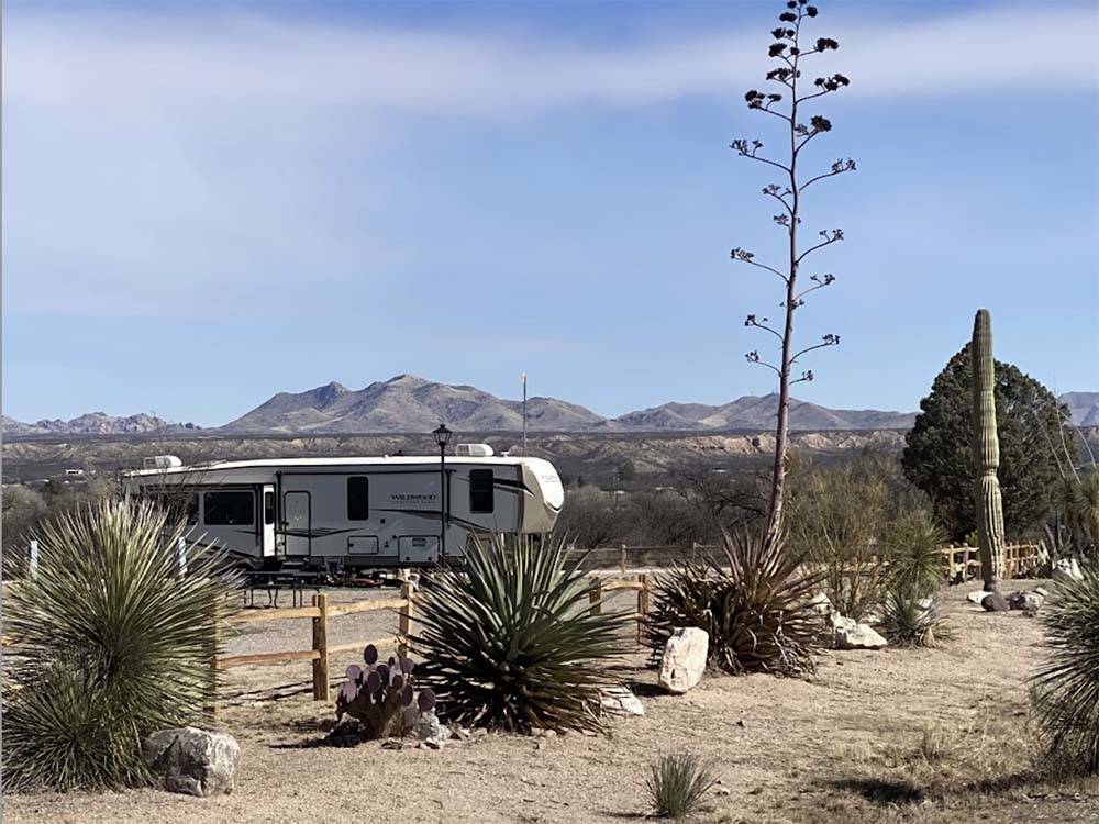 A travel trailer in a site with the mountains in the distance at BENSON KOA JOURNEY