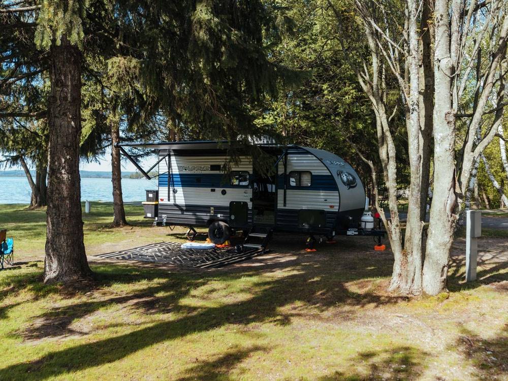 A travel trailer at a shaded site