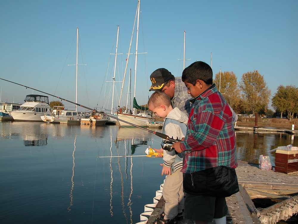 A couple of young boys fishing off a dock at BOARDMAN MARINA & RV PARK