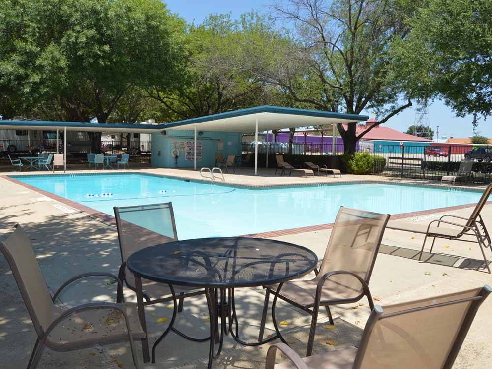 Swimming pool with table and chairs at TRADERS VILLAGE RV PARK
