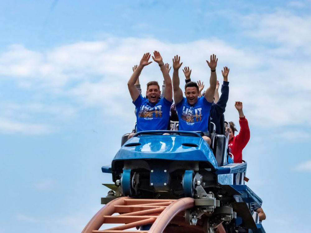 People at the crest of a roller coaster