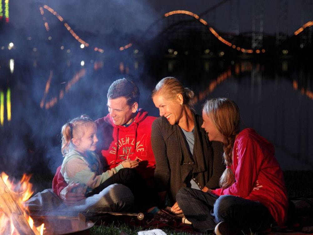 A family sitting around a campfire at night