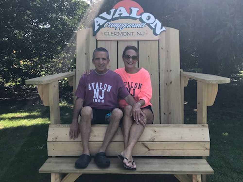 Two people sitting in an oversized chair at AVALON CAMPGROUND