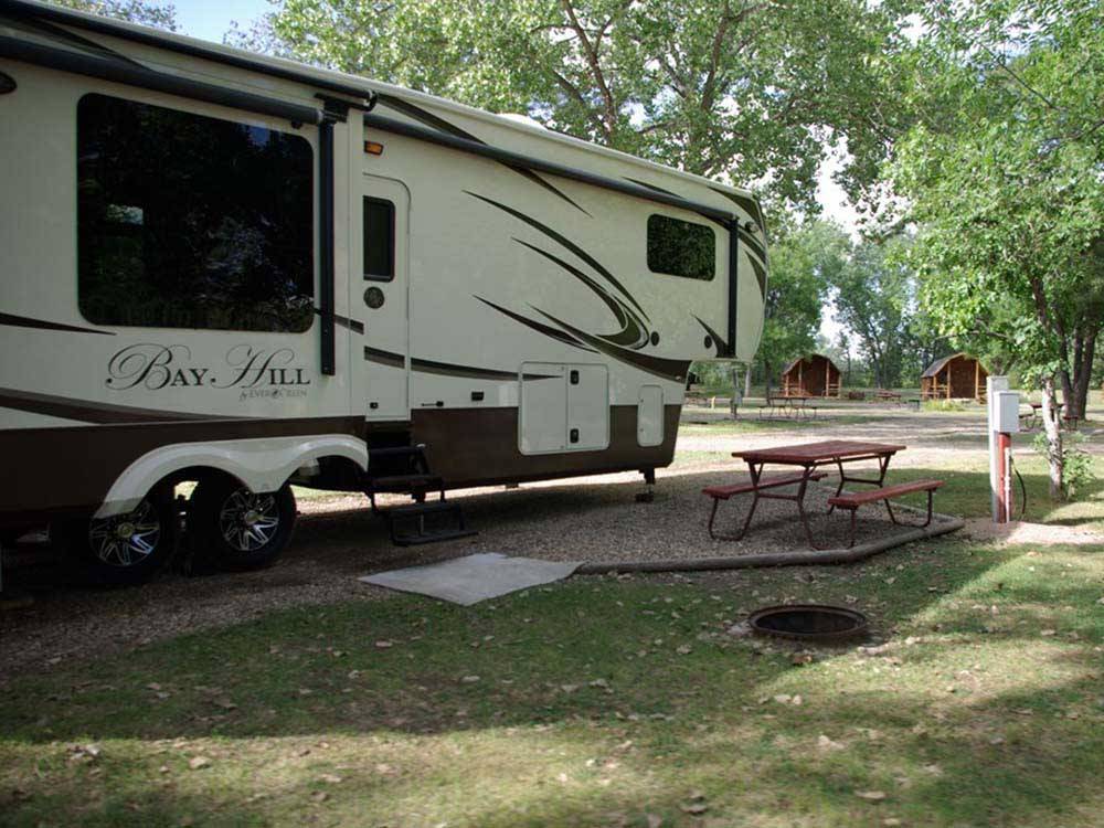 A travel trailer in a gravel site at BADLANDS / WHITE RIVER KOA HOLIDAY