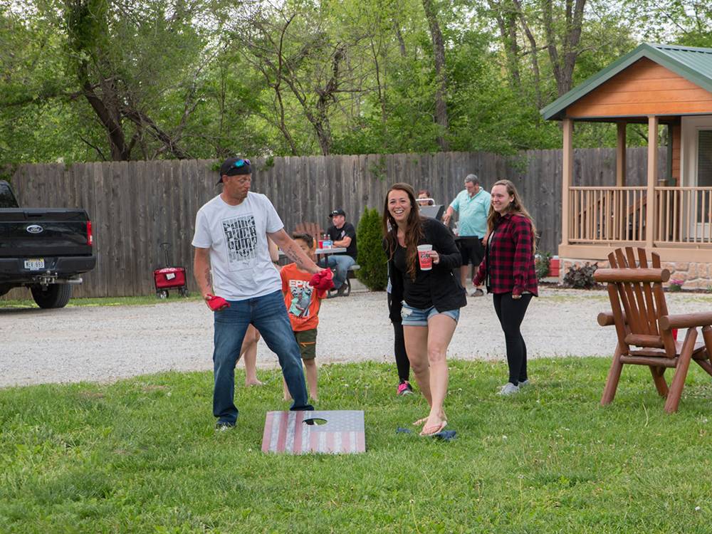 A group of people playing cornhole