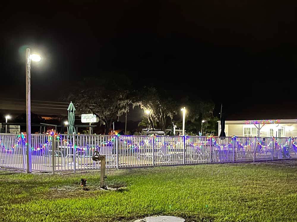 The fence around the swimming pool lit up at CYPRESS CAMPGROUND & RV PARK