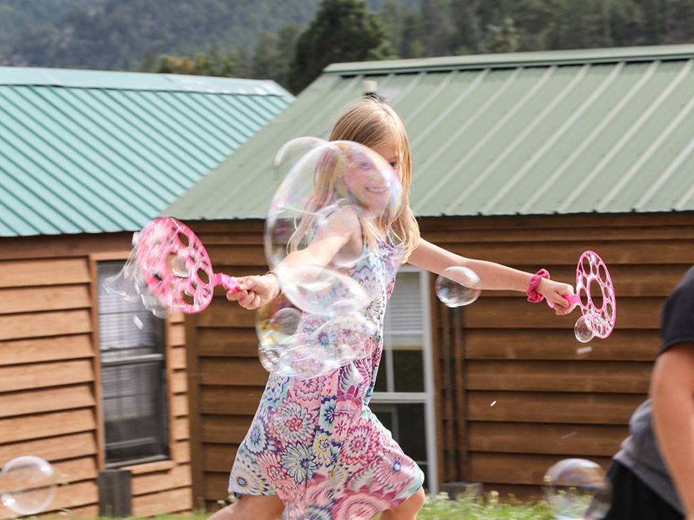 Little girl playing with bubbles at JELLYSTONE PARK ESTES