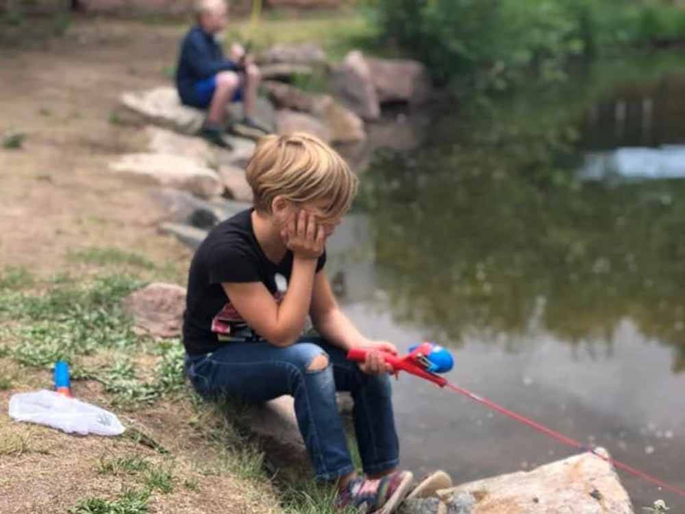 A child fishing in the lake at LONE DUCK CAMPGROUND
