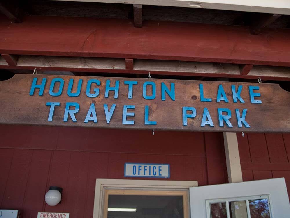The campground name above the office sign at HOUGHTON LAKE TRAVEL PARK CAMPGROUND