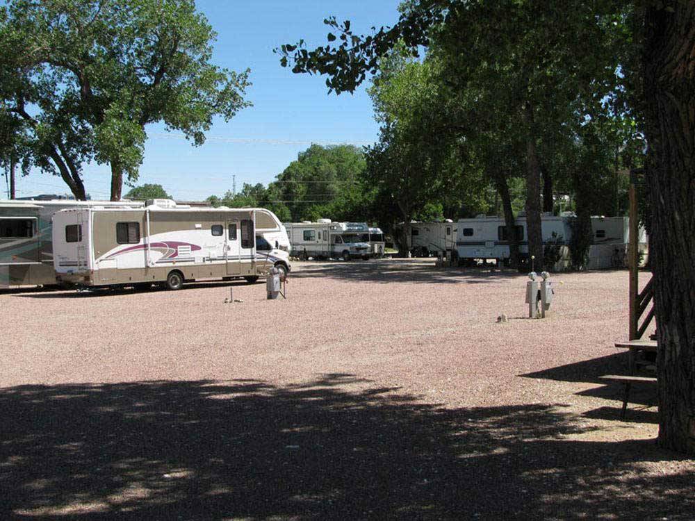Large graveled area with surrounding RV units at GOLDFIELD RV PARK