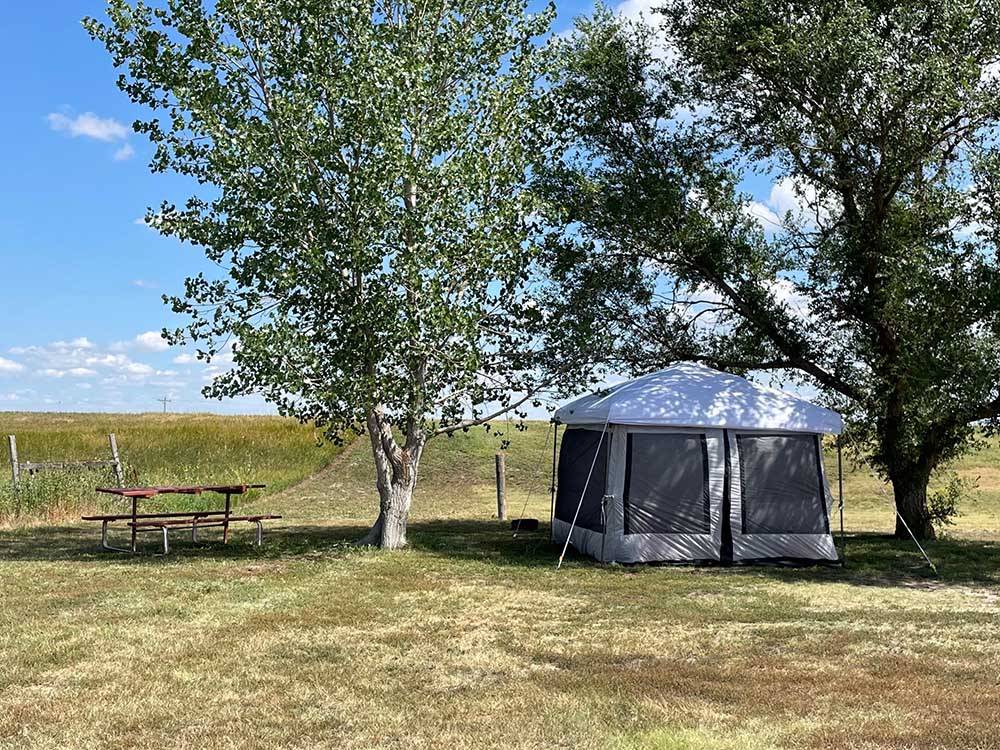 A tent and picnic table at BADLANDS MOTEL & CAMPGROUND