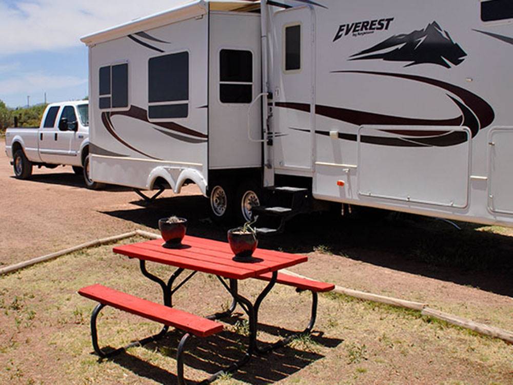A picnic table next to a parked RV at VAN HORN RV PARK