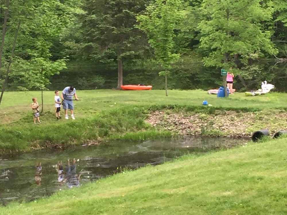 A family fishing from the water's edge at BEAVER MEADOW FAMILY CAMPGROUND
