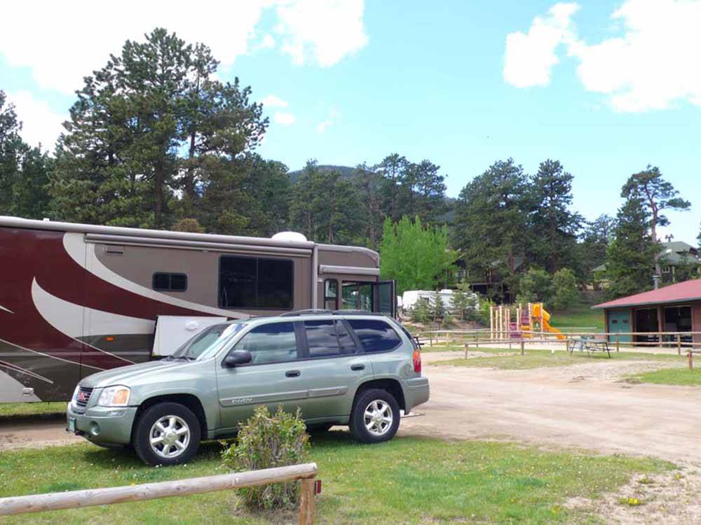 A car and motorhome in an RV site at SPRUCE LAKE RV RESORT