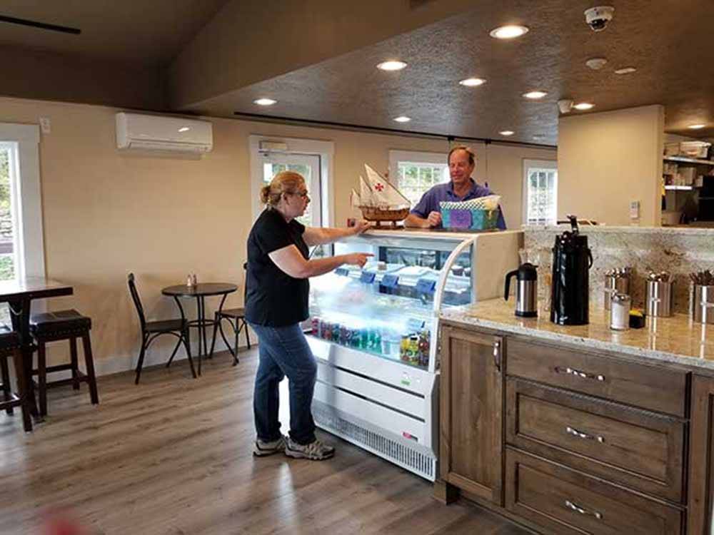 A woman buying a muffin in the onsite convenience store at NETARTS BAY GARDEN RV RESORT