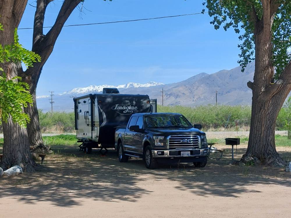Trailer and truck under trees