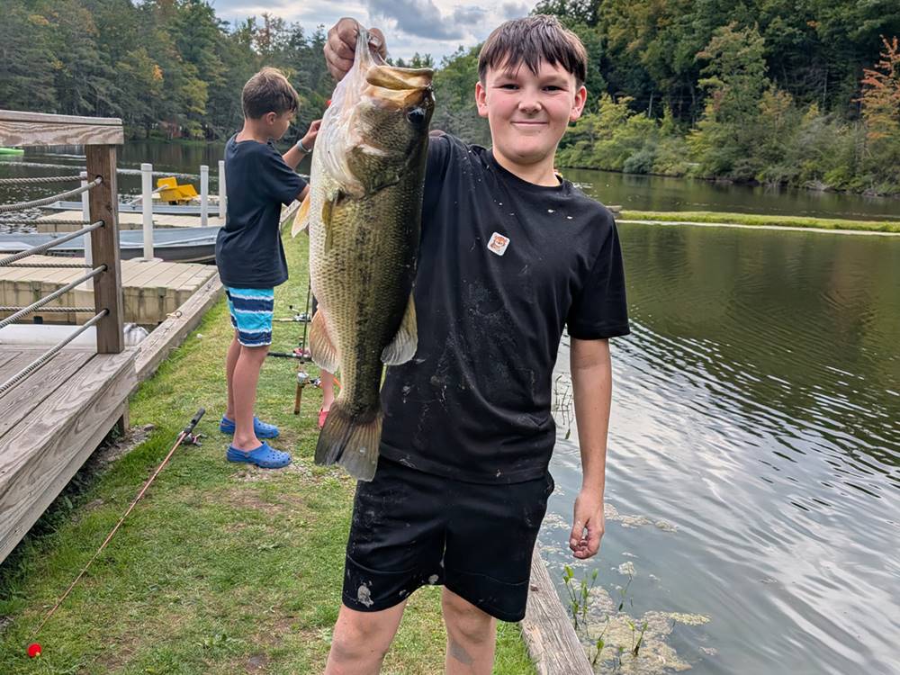 A boy holding up a fish he caught