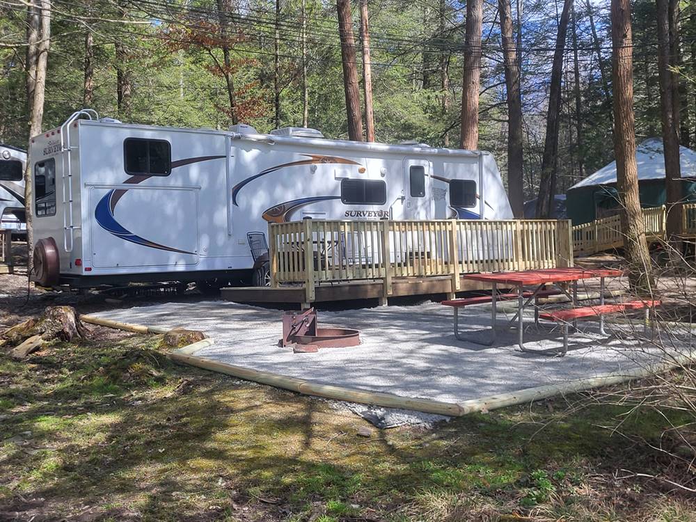 A shady RV site with deck and patio