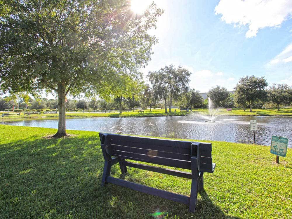 Bench next to the lake with a fountain at ENCORE SPACE COAST