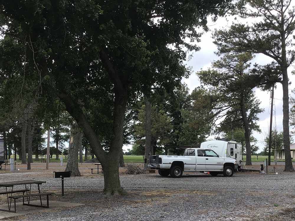 A truck and trailer in a gravel RV site at BOOTHEEL RV PARK & EVENT CENTER