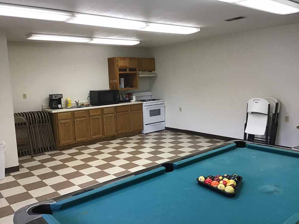The pool table and communal kitchen at BOOTHEEL RV PARK & EVENT CENTER
