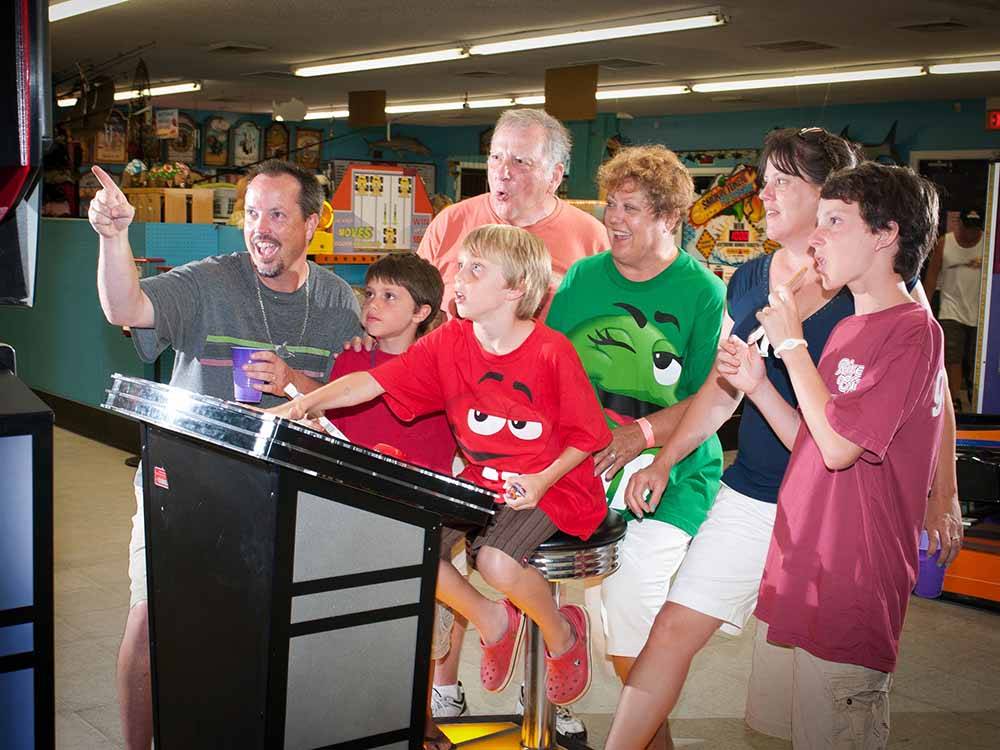 A family playing an arcade game at APACHE FAMILY CAMPGROUND & PIER