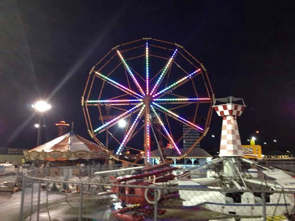 Carnival rides lit up at night nearby at CAMP PEDRO CAMPGROUND