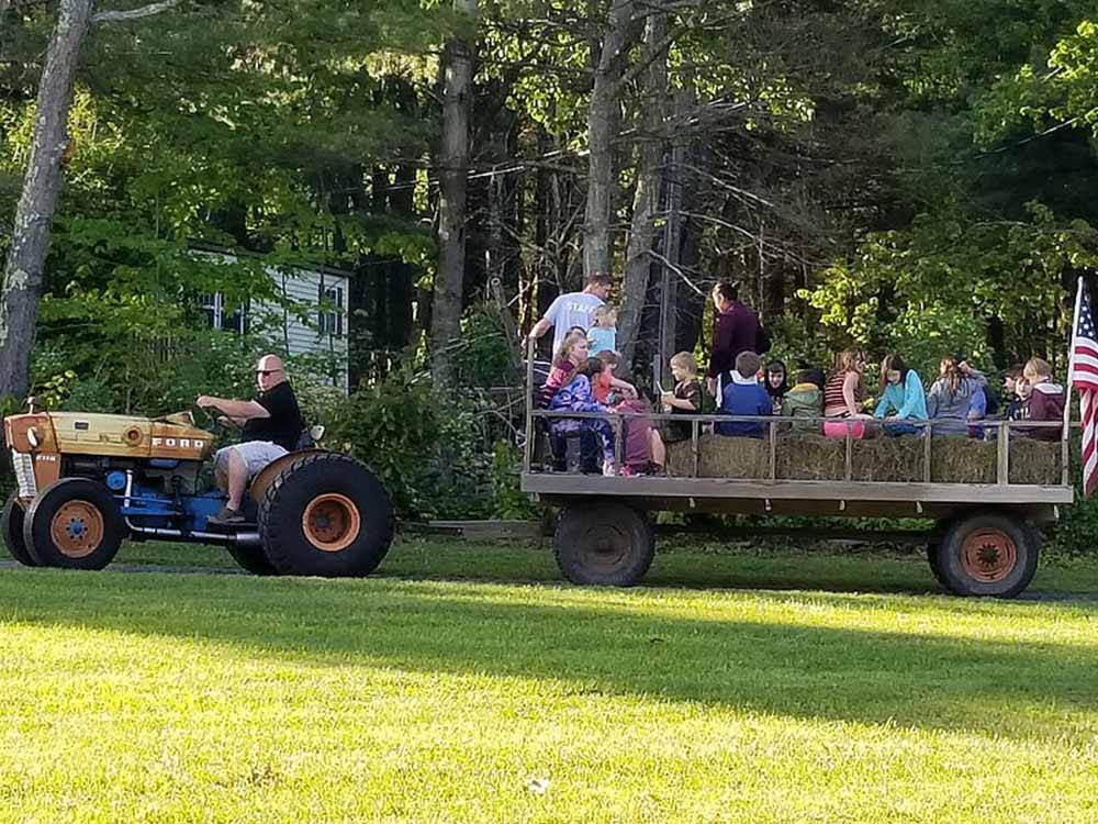 A man on a tractor pulling people for a ride at COUNTRY ROADS CAMPGROUND