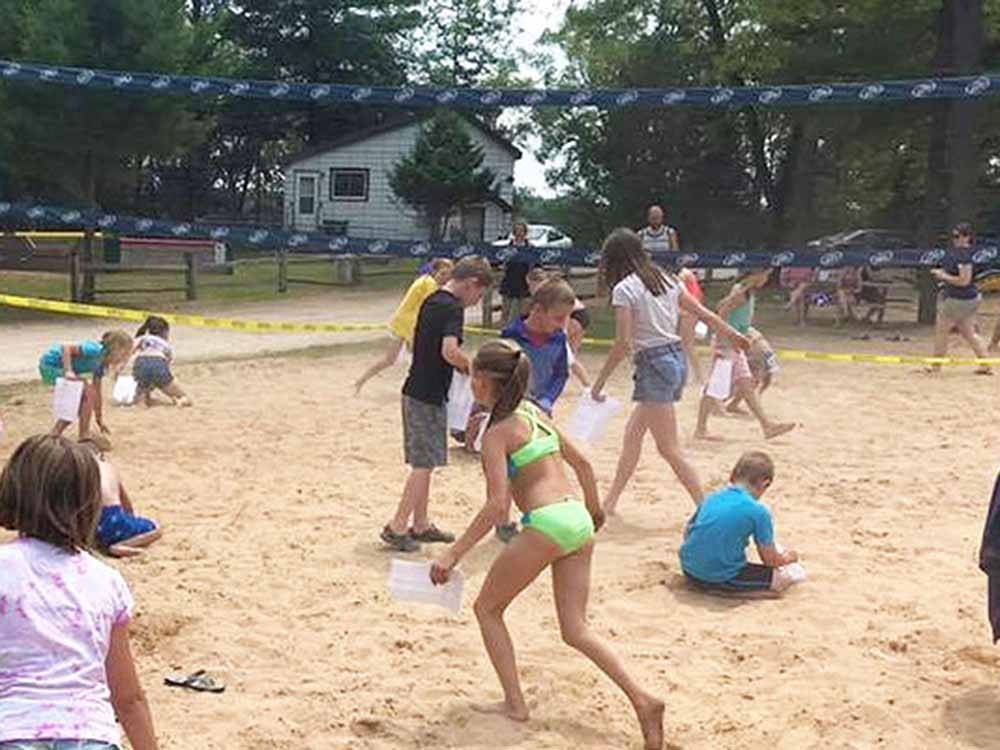 Kids and adults in sand volleyball court at BUFFALO LAKE CAMPING RESORT
