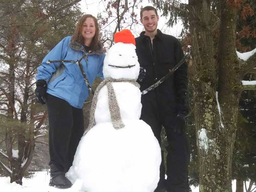 Couple with snowman at FOUR SEASONS CAMPGROUNDS