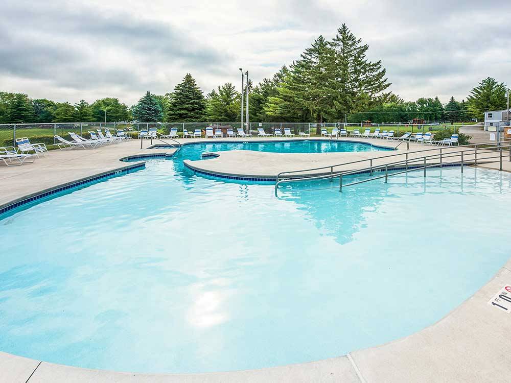 Swimming pool with outdoor seating at PLYMOUTH ROCK CAMPING RESORT