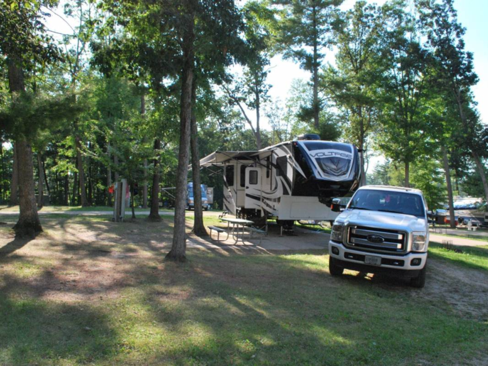 Truck and trailer in grass site at Jellystone Park Warrens