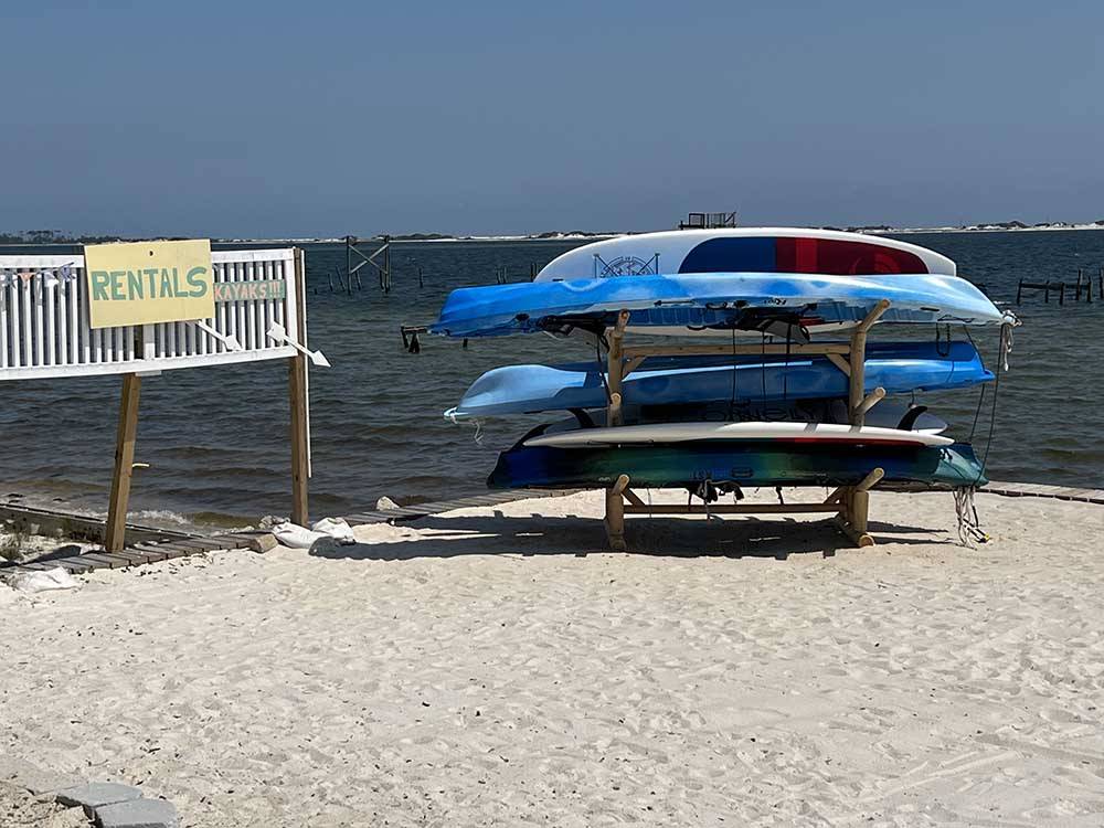 A stack of kayaks on the beach at NAVARRE BEACH CAMPING RESORT