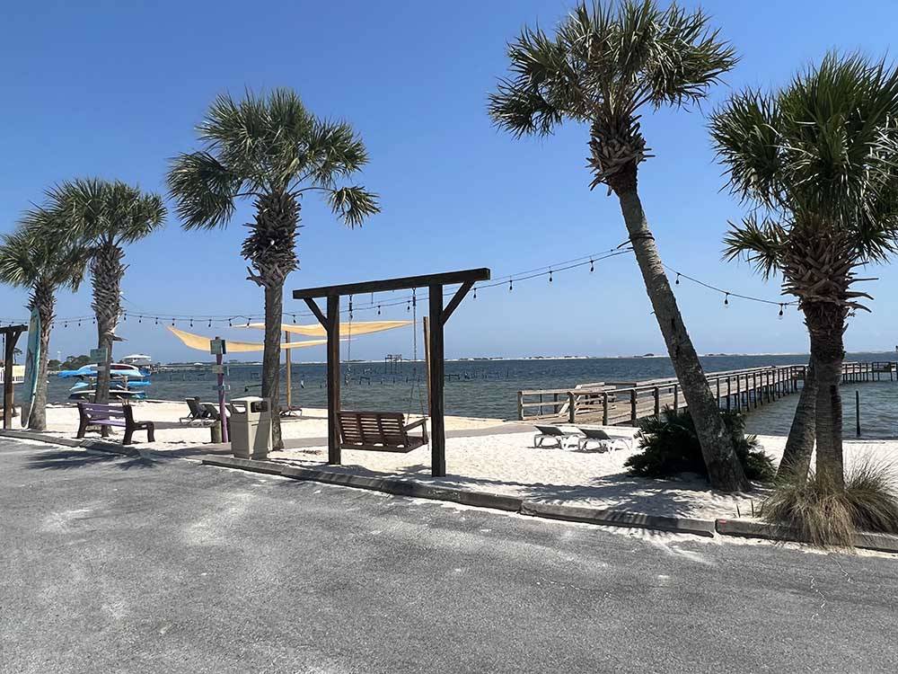 A wooden bench swing next to the pier at NAVARRE BEACH CAMPING RESORT