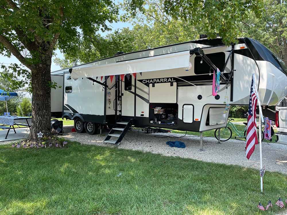 A fifth wheel trailer in a gravel RV site at OSAGE BEACH RV PARK