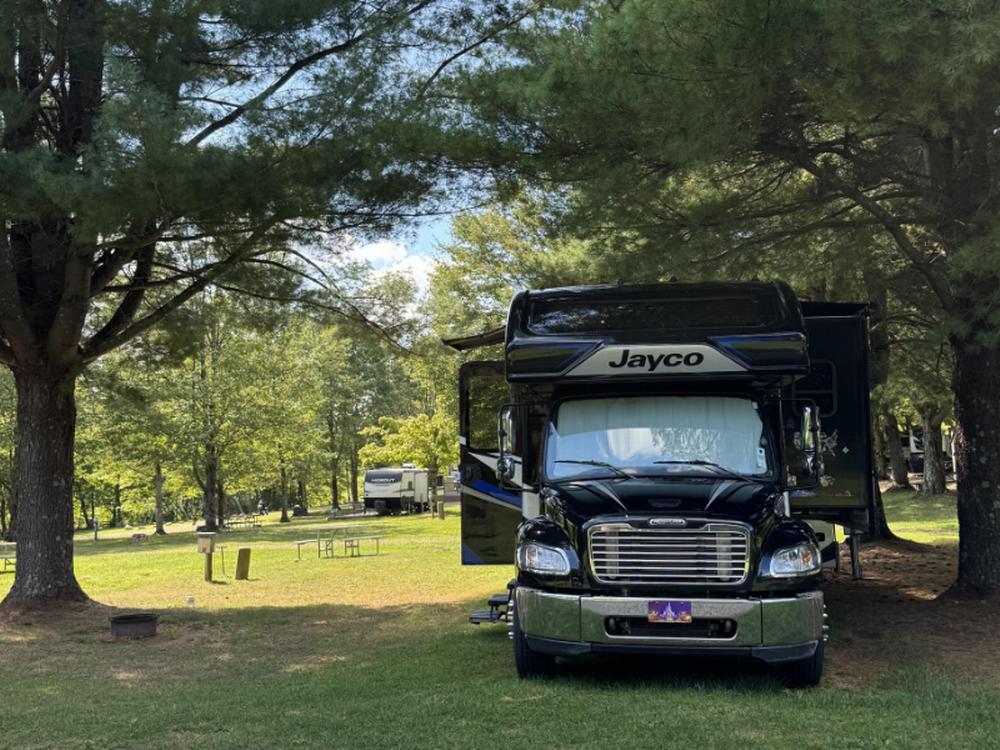 A big rig RV under a shade tree