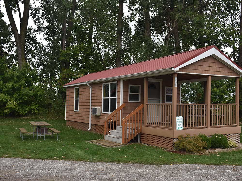 A brown rental cabin with a picnic table at FRANKENMUTH YOGI BEAR'S JELLYSTONE PARK CAMP-RESORT