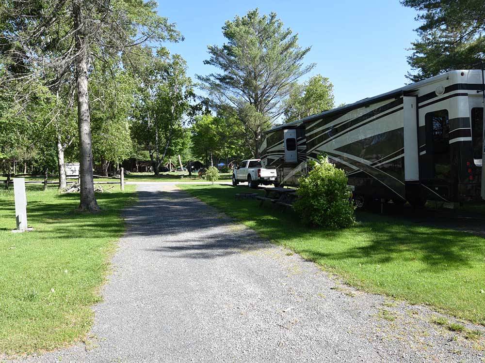 A trailer parked next to an empty site at GREAT CANADIAN RESORTS & CAMPGROUNDS