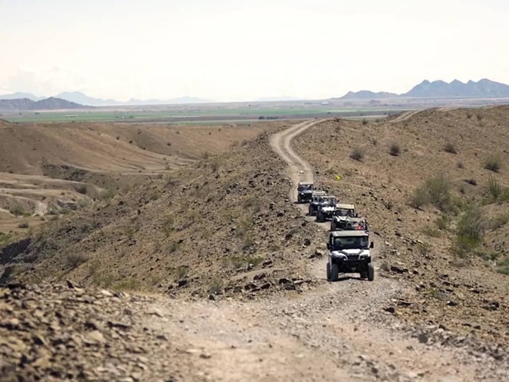 ATVs riding on a dirt path nearby