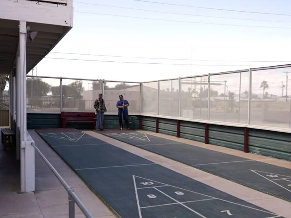 Two men playing shuffleboard