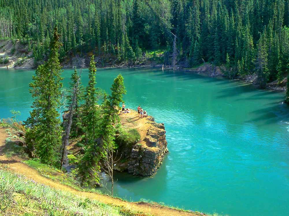 Aerial view of emerald lake with bathers on bluff at CARIBOU RV PARK
