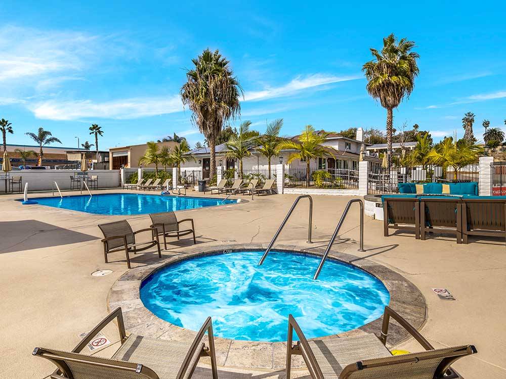 A large community fire pit surrounded by blue chairs at OCEANSIDE RV RESORT