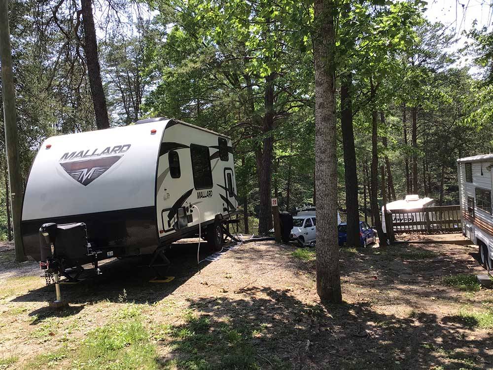 A travel trailer in a dirt RV site at PARADISE LAKE AND CAMPGROUND