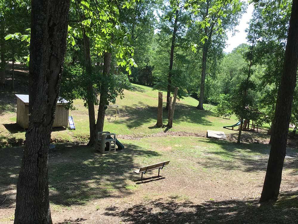 A playground area with a park bench at PARADISE LAKE AND CAMPGROUND
