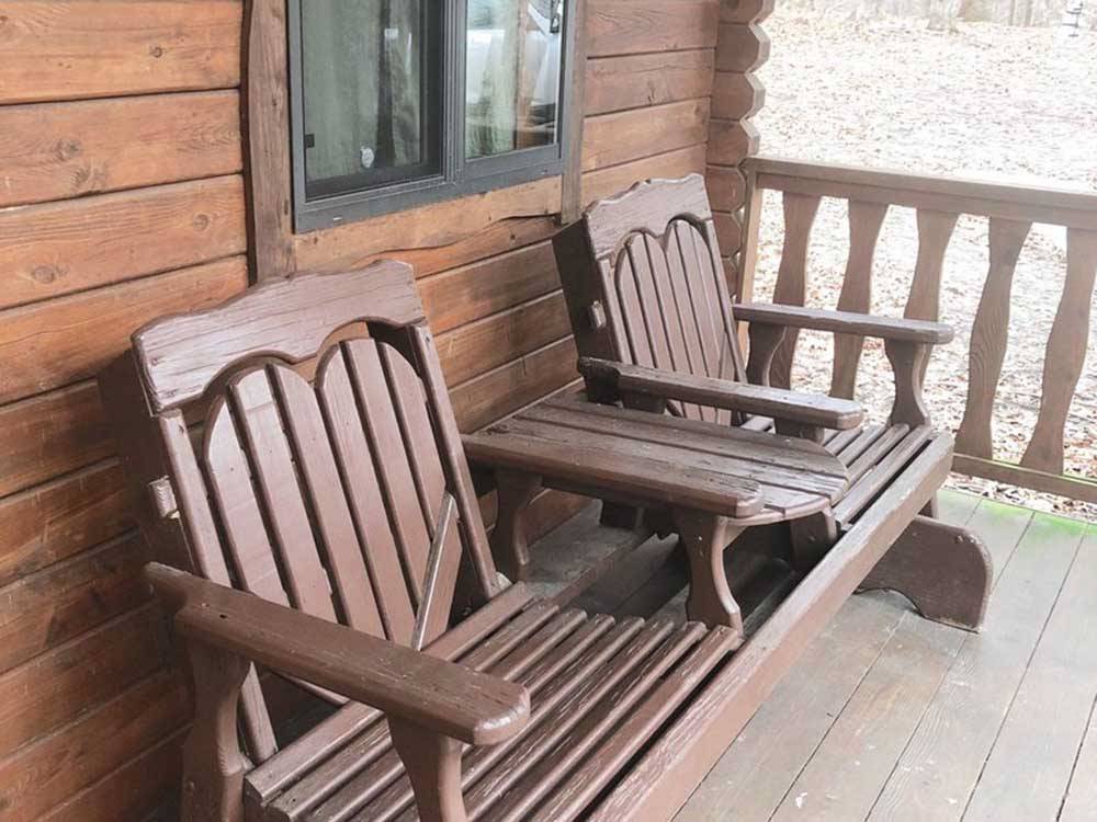 A siding park bench on the deck of a rental cabin at PARADISE LAKE AND CAMPGROUND